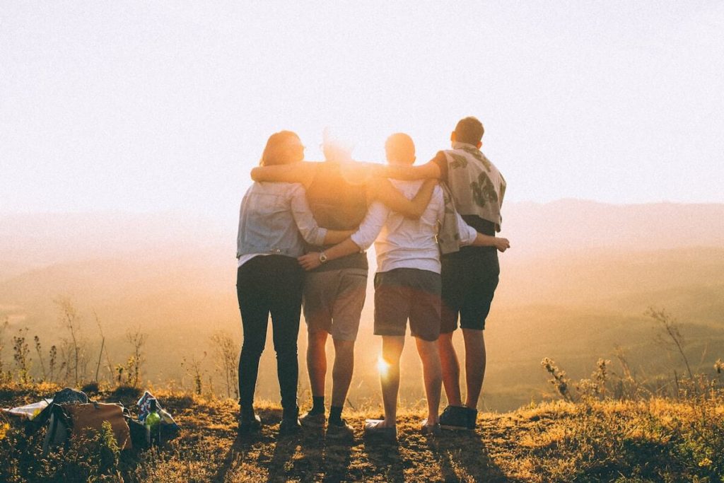 Vier Freunde zusammen in der Natur bei Sonnenuntergang