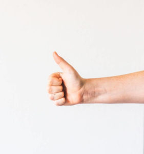 Unterarm und Hand mit Daumen hoch