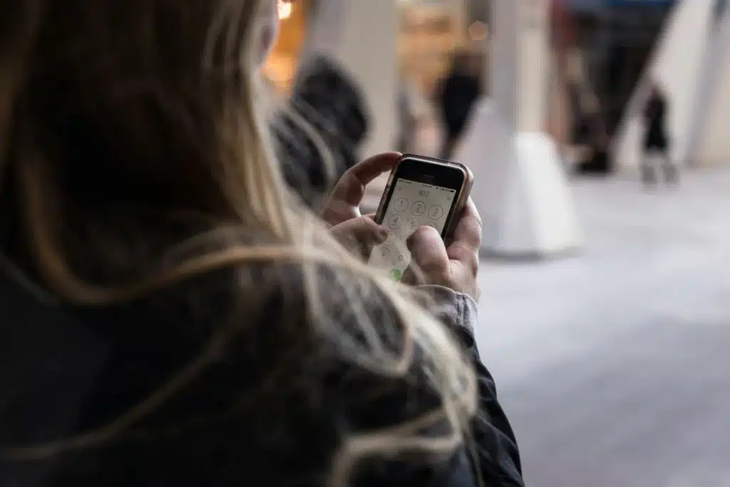 Frau mit Smartphone, die am Screen tippt für Kundenservice